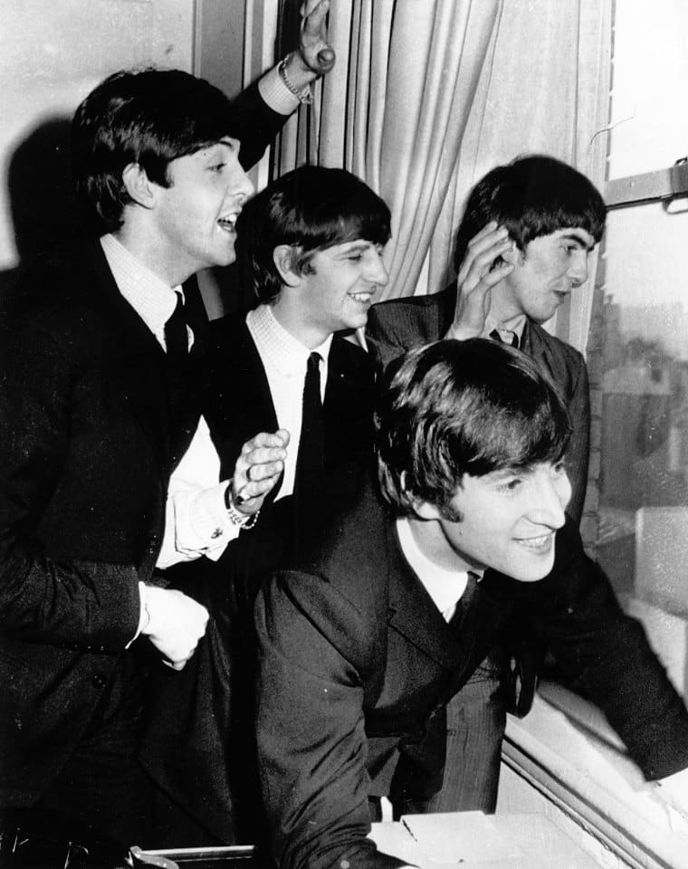 The Beatles wave to fans assembled below their Plaza Hotel window after they arrived in New York City on Feb. 7, 1964 for a short tour of the United States