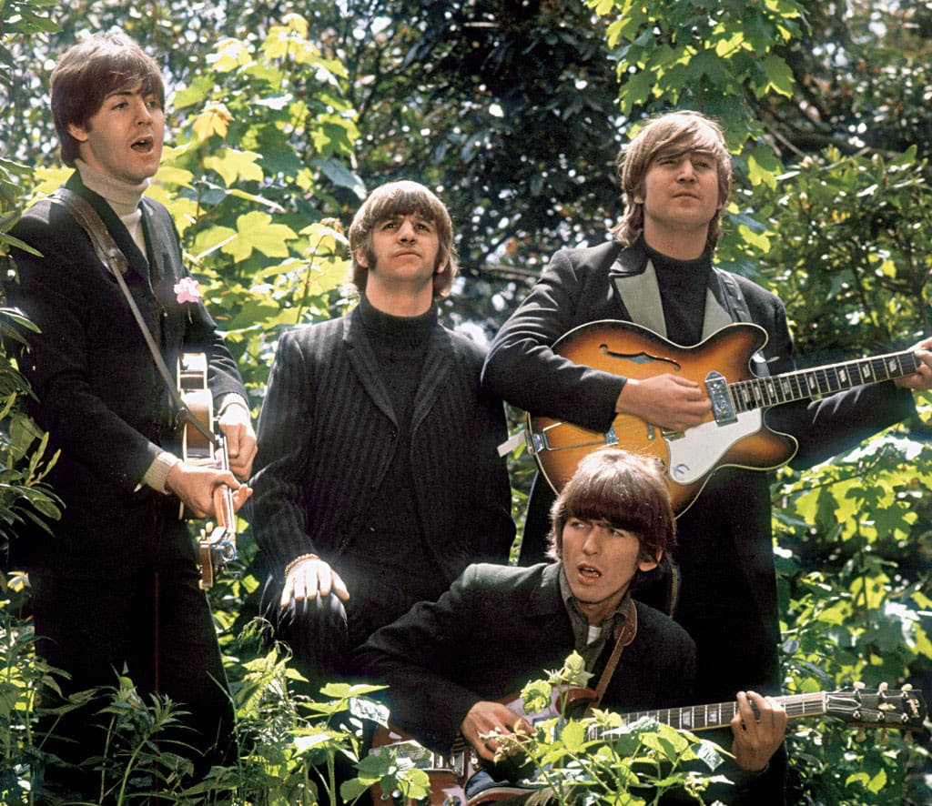 The Beatles walk and sing as they are filmed during a promotional video for their song