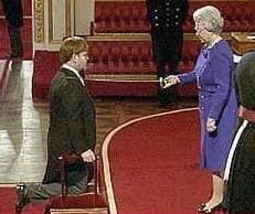 February 24, 1998 - England's Queen Elizabeth II knighted Elton John during a ceremony at Buckingham Palace