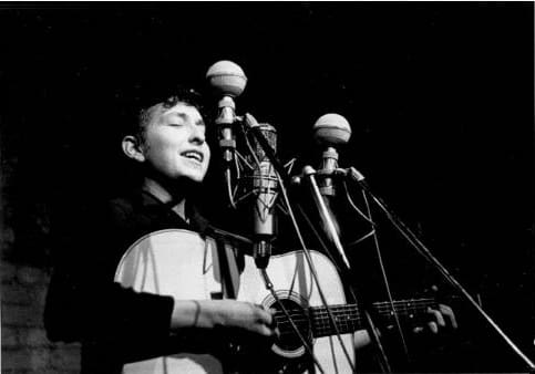 Bob Dylan performs at The Bitter End folk club in Greenwich Village in 1961. by Sig Goode