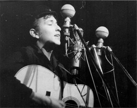 Bob Dylan performs at The Bitter End folk club in Greenwich Village in 1961. by Sig Goode