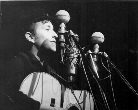 Bob Dylan performs at The Bitter End folk club in Greenwich Village in 1961. by Sig Goode
