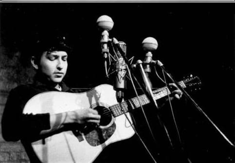 Bob Dylan performs at The Bitter End folk club in Greenwich Village in 1961. by Sig Goode